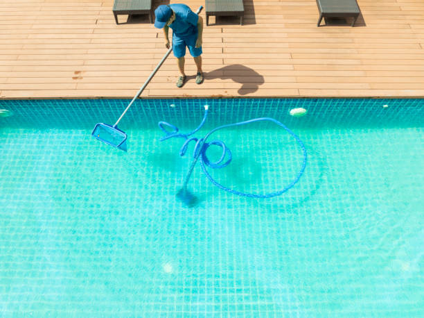 Pool technician cleaning a pool with a skimmer net
